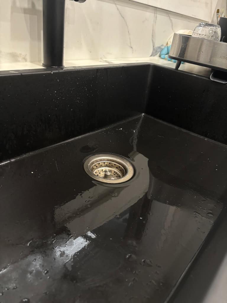 wet and stained black kitchen sink