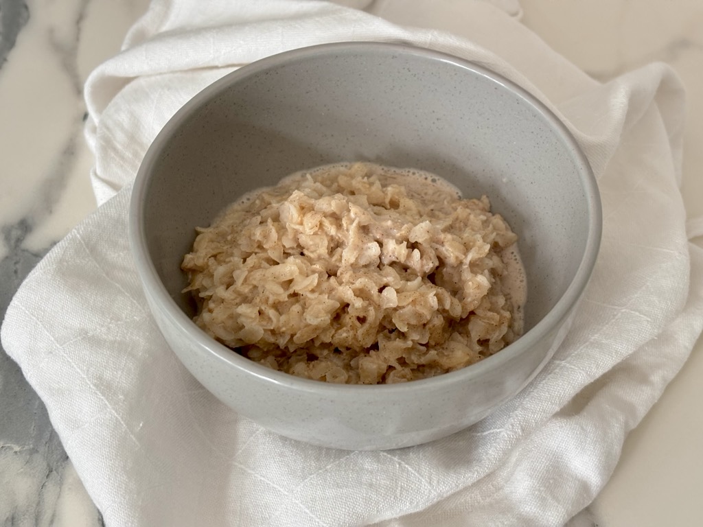 Rice Flakes Porridge in grey bowl on white linen napkin