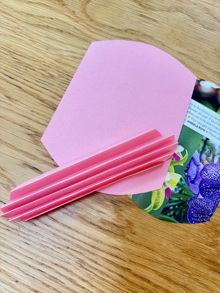 Three pieces of paper shaped to be folded into paper hearts