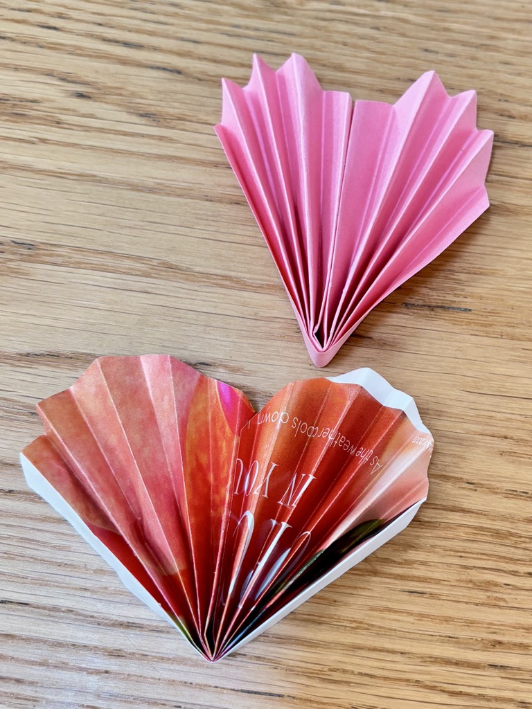 Two paper hearts on wooden table