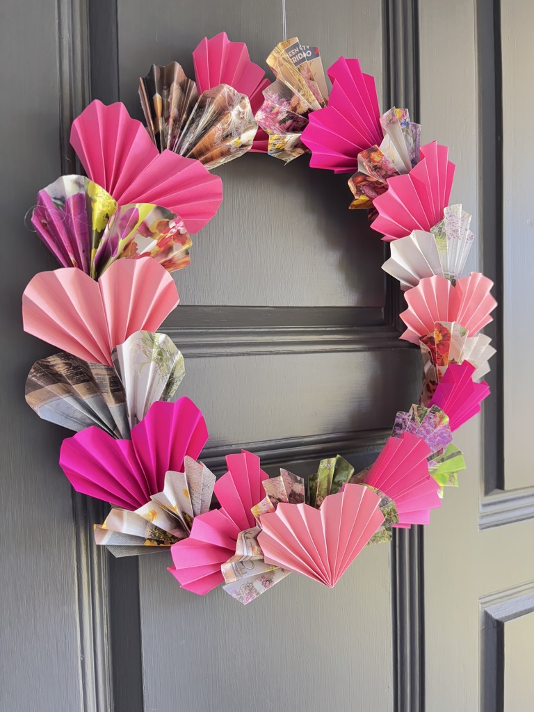 side shot of pink paper heart wreath on grey door