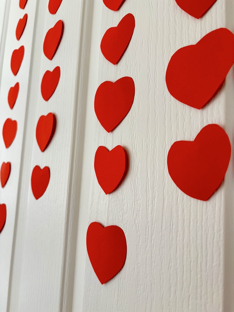 Red heart garlands against white door