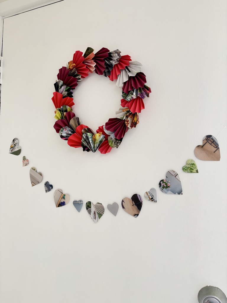 Door with red paper heart wreath and multi-coloured heart garland hung below it