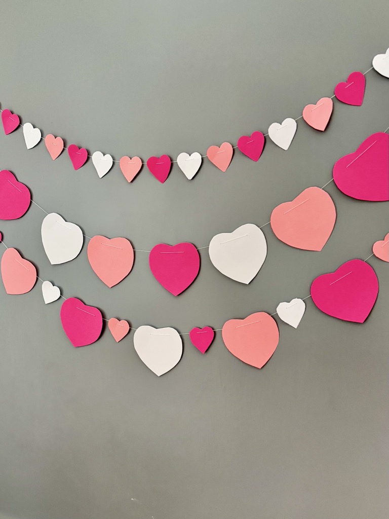 Pink and white heart garlands against grey background