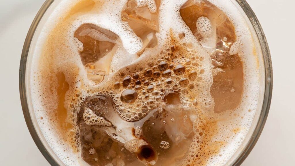 Top down close up shot of iced coffee in glass