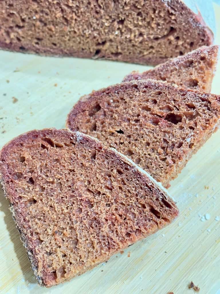 Slices of pink sourdough bread on wooden board