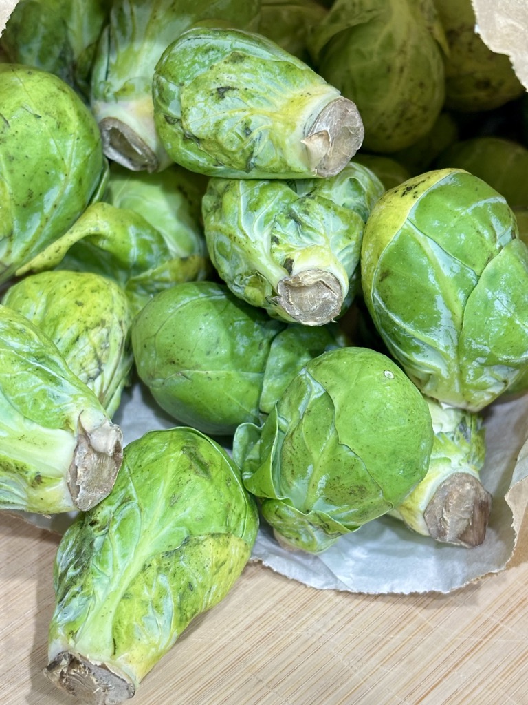 paper bag filled with raw Brussels sprouts