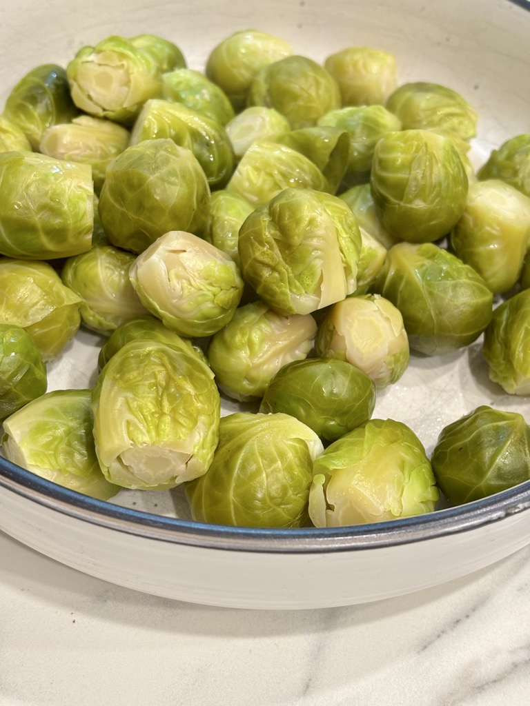 White bowl filled with steamed Brussels sprouts