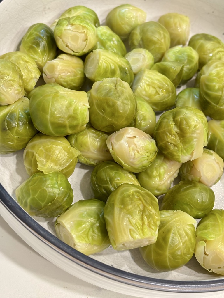 White bowl filled with steamed Brussels sprouts