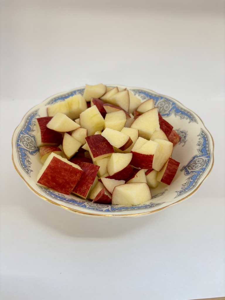 Chunks of red apples in blue and white vintage bowl