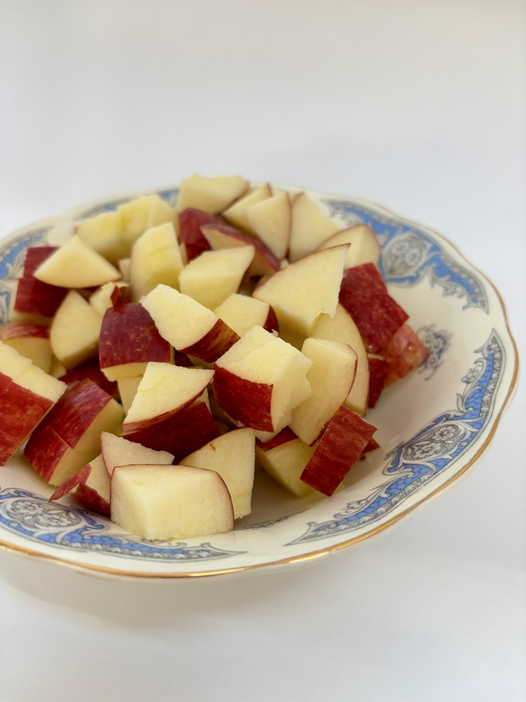 Chunks of red apples in blue and white vintage bowl