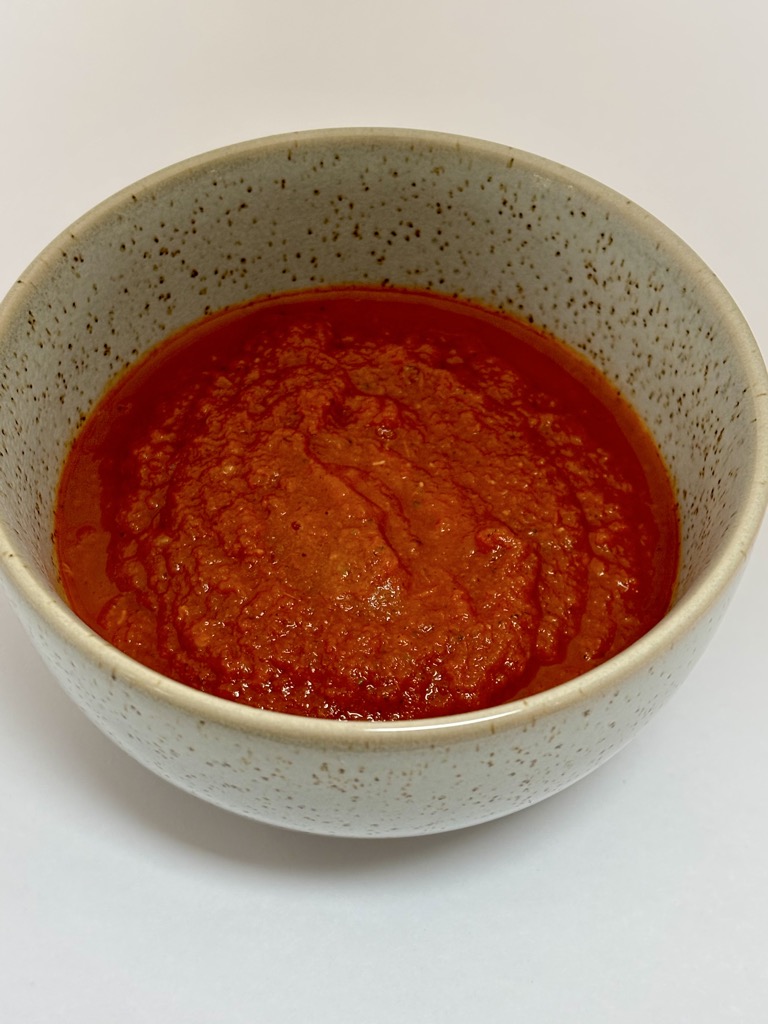 Small bowl filled with deep red tomato sauce