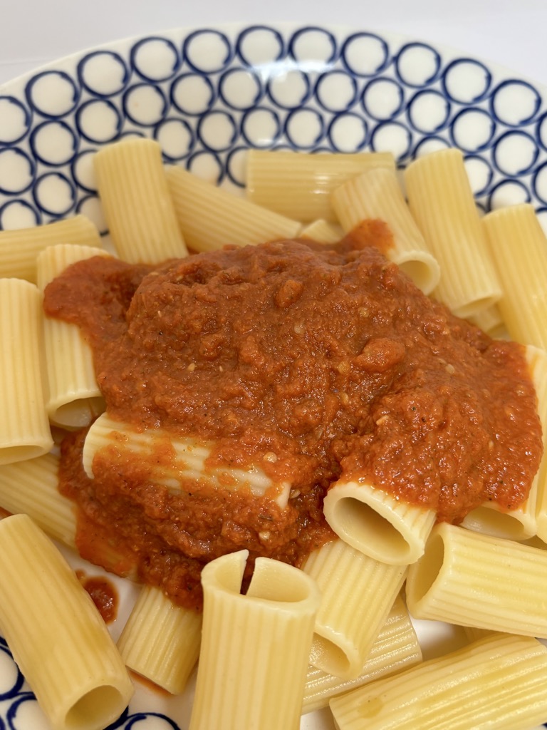 Close up shot of paste topped with fresh tomato sauce