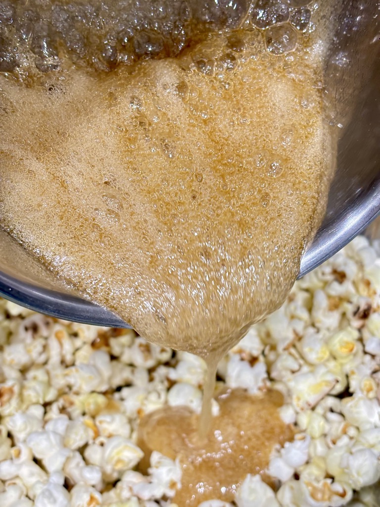 Caramel sauce being poured over popcorn