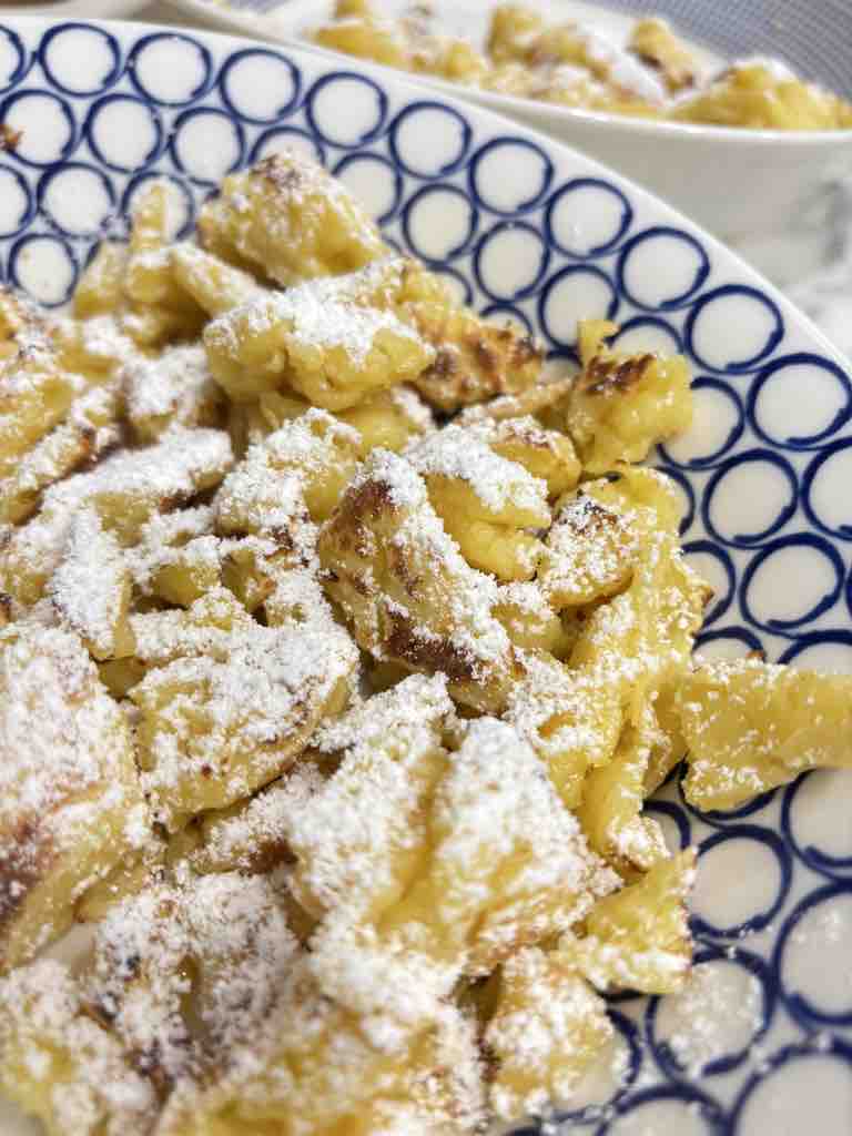 Traditional Austrian pancakes (Kaiserschmarrn) served golden and crispy, generously sprinkled with icing sugar.