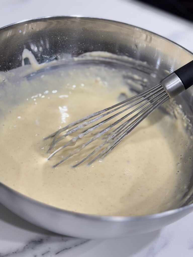 Whisking smooth batter for traditional Kaiserschmarrn pancakes – the perfect base for fluffy Austrian treats.