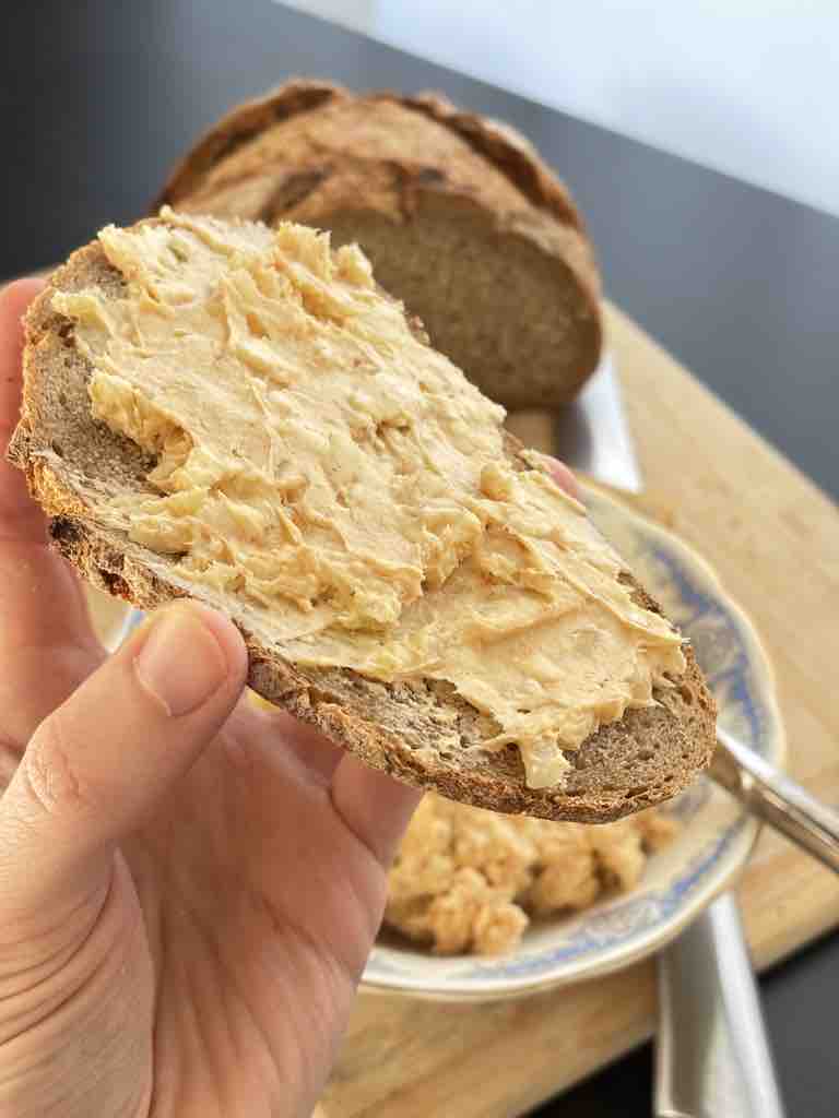 Close-up of obatzda cheese spread on bread, highlighting the creamy, spiced texture of the dip.