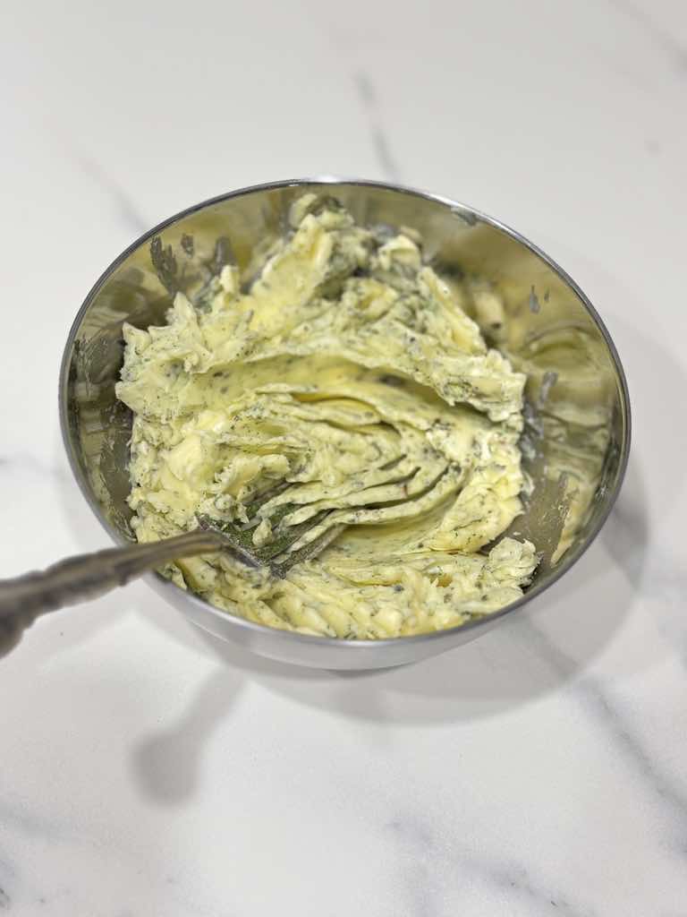A bowl of rustic herb butter made with dried herbs, freshly mixed using a fork — part of a simple old-school German recipe.