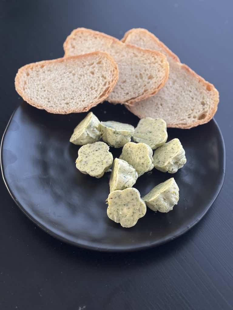 A full view of an old-school serving of homemade herb butter with dried herbs and rustic bread, inspired by simple German cooking traditions.