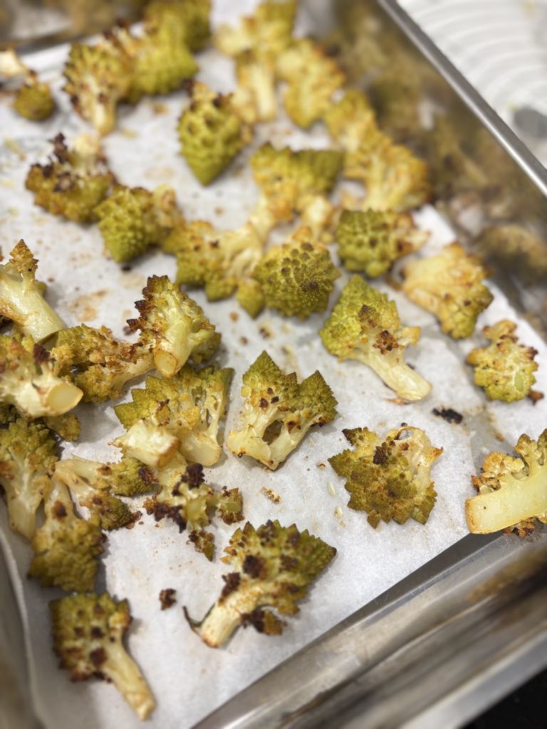 A tray of roasted Romanesco green cauliflower with browned tips, showing the perfect texture and flavor of this rustic green cauliflower recipe.