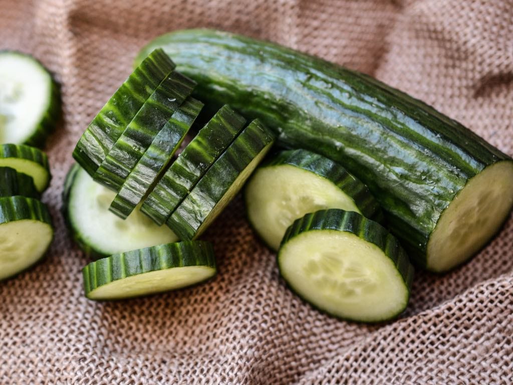 Thick cucumber slices resting on a rustic cloth, ready to be turned into crunchy refrigerator dill pickles. A simple start to any homemade pickles recipe.