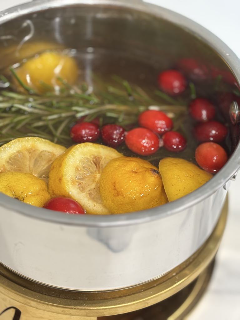 Natural winter simmer pot made with fresh fruit, rosemary, and cranberries for a warm seasonal aroma.