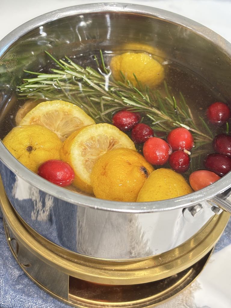 Traditional stovetop potpourri using lemon, rosemary, and cranberries simmered in water for a homemade air freshener.