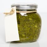 Homemade basil pesto in a rustic glass jar with twine label, ideal for freezer storage and demonstrating how to freeze basil pesto for later use.